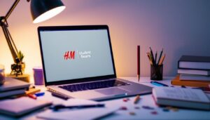Een open laptop toont H&M-website en Student Beans-logo op rommelig bureau.